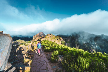 Obraz na płótnie Canvas Woman hiking along scenic hike trail to Pico Ruivo in the morning. Pico do Arieiro, Madeira Island, Portugal, Europe.