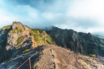 Woman enjoying mountain scenery from scenic hike trail to Pico Ruivo in the morning. Pico do...
