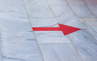 The red arrow on the marble floor points to the right