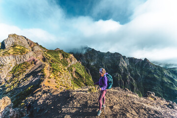 Woman enjoying mountain scenery from scenic hike trail to Pico Ruivo in the morning. Pico do...