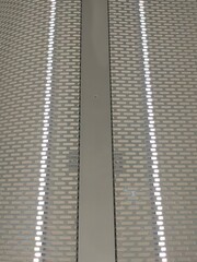 decorative gray metal grating closing led lamps on the wall of the shopping center