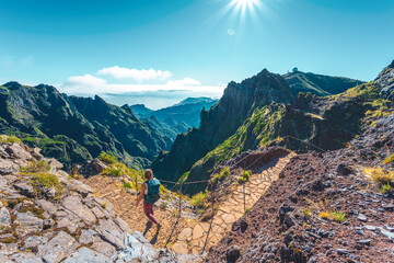Woman with backpack hiking along very scenic hike trail to Pico Ruivo in the morning. Pico do...