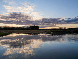 Autumn sunset tree reflection. Sunset sky over river trees. 