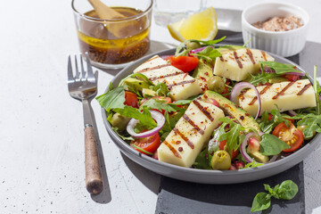 Salad with fried Halloumi cheese, cherry tomatoes, arugula and pomegranate seeds. healthy food. copy space