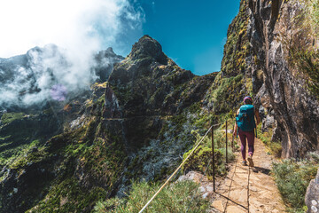 Hiker with backpack walking along very scenic hike trail to Pico do Ariero in the afternoon. Verade...