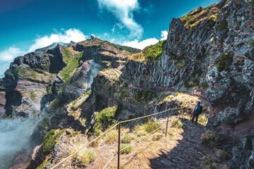 Sportive woman with backpack walking along super scenic hike trail to Pico do Ariero in the...