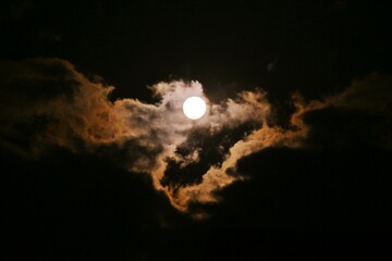A view of the full moon and clouds. Background image of the moon.