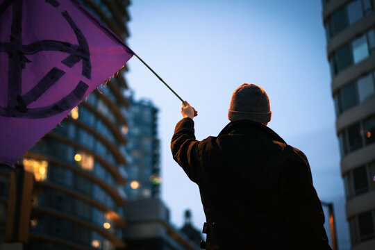 Vancouver Canada - November 21, 2021: A woman holds a sign while protestors block traffic during a Vancouver Canucks game near Downtown Vancouver