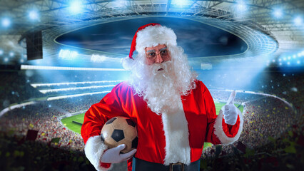 Positive Santa claus with football ball in hand