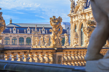 Naklejka na ściany i meble Cityscape - view of a sculptures on the balustrade against the backdrop of the architecture Zwinger Palace complex in Dresden, Germany