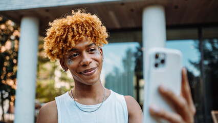 Young multiracial man having online video call on smartphone app with friend