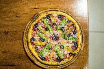 Black pizza with tomatoes, sausages, mozzarella and basil. Dough with healthy bamboo charcoal powder