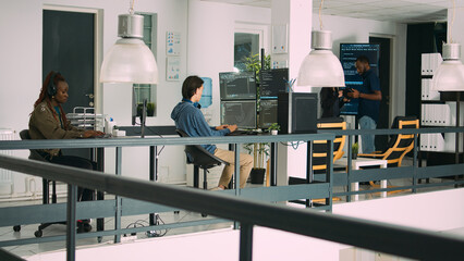 Senior developers coding on laptop in software agency office, parsing code and developing it language. Team innovating machine learning algorithms and using firewall security server.