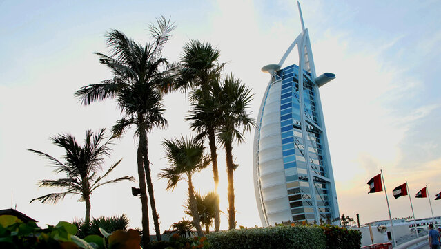 DUBAI, UNITED ARAB EMIRATES, UAE - NOVEMBER 20, 2017: Hotel Burj al Arab , at sunset, palms are seen, flags are developing in the wind. High quality photo