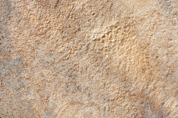Old stone wall is sand or orange in color with real patterns. Textured stone background of real wall.