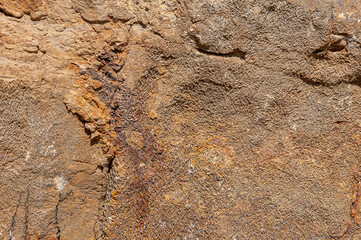 Stone natural wall of sand color with multi-colored spots everywhere. Textured stone background with real patterns.