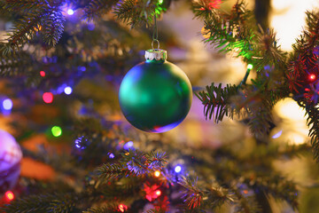 Obraz na płótnie Canvas Shiny Christmas ball hanging on Christmas tree with festive background.