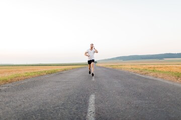 Obraz premium Man in earphones running outdoors