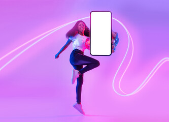 Joyful african american woman jumping with cell phone, mockup