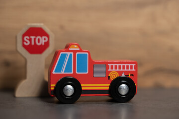 petit camion de pompier en bois devant un stop jouet pour enfant