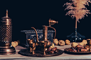 Persian Tea and teapots pouring hot tea in tea cups at a table.