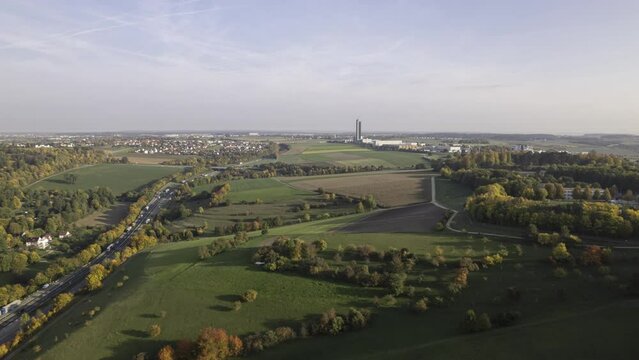 Colorful trees and meadows along highway and a tower in autumn aerial time lapse