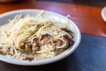 plate of meat cannelloni with grated cheese and mushrooms in restaurant