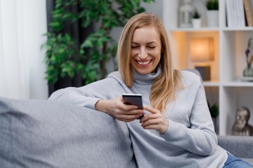 Woman using smartphone on couch