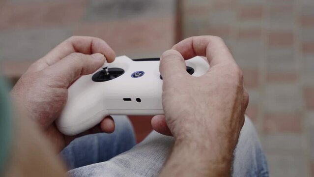 Closeup male hands remote control sticks of controller of FPV racing drone