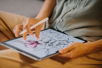 Artist or designer making new project, drawing on a graphic tablet with pencil, close-up on a...