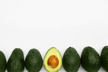 Tasty whole and cut avocados on white background, flat lay. Space for text