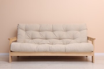 Comfortable sofa near beige wall on floor indoors