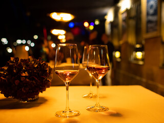 Two glasses with sparkling wine standing on a table. Warm tungsten light is illuminating the scene. Lipstick is on the glass. The alcoholic beverages are tradition at a social event in a German club.
