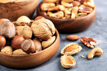 various nuts in a wooden bowl and a nutcracker. Close-up. selective focus.
