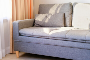 Gray sofa next to curtains close-up side view.