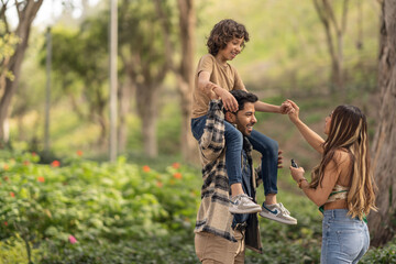 Cheerful family dancing together in a park