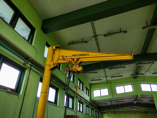 Naklejka premium 500 Kgs capacity of yellow crane standing in the manufacturing area.