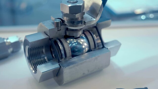 Internal structure of modern stainless steel ball valve with blue lever used in the industry and home plumbing. Shot in motion. Closeup