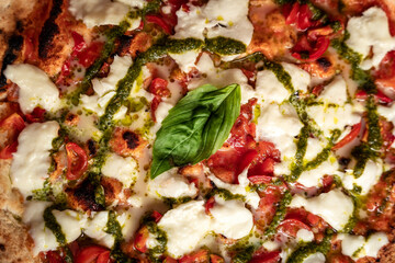 Mozzarella bufala pizza in a box, take away, ordered vegetarian italian food, basil pesto, top view detail