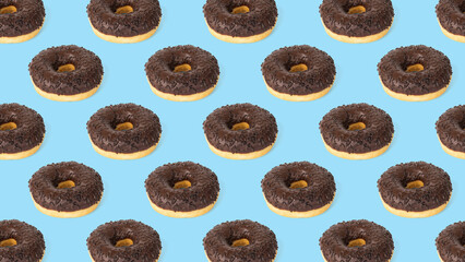 A pattern of fresh chocolate donuts on a blue background.