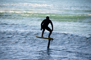 View of man riding foilboard (hydrofoil surfboard, foilsurfing)