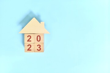 New year 2023 house or home ownership and real estate property concept. Wooden blocks on blue...