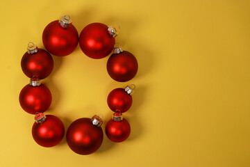 red Christmas ornament balls on yellow background. Flat lay, top view, copy space