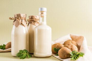 Vegan vegetable milk from potatoes is a new trend in food consumption. two bottles of milk opposite...