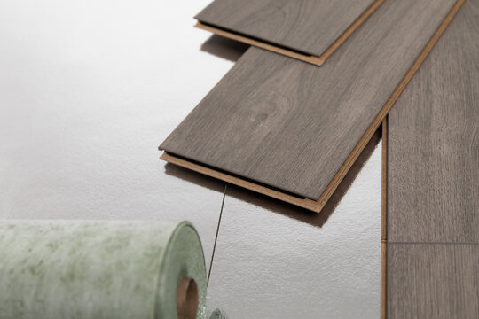 Installation of floating floor, underlay with sheets of laminate. Home improvement concept.