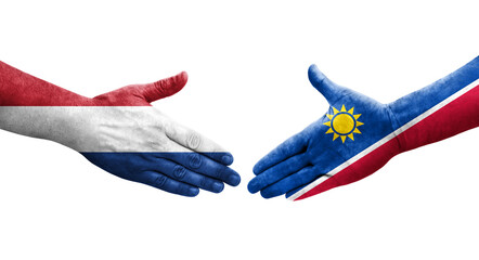 Handshake between Namibia and Netherlands flags painted on hands, isolated transparent image.