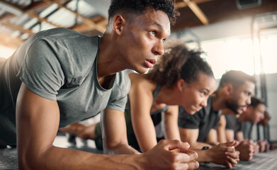 Gym, fitness and plank floor workout, challenge and power exercise by young people, focus and mindset. Training, planking and group on the ground for wellness, health and muscle, energy and strength