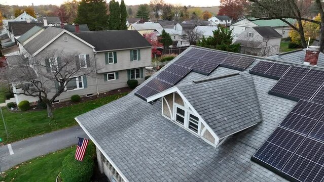 American home with USA flag and green renewable energy theme. Rooftop solar power unit for electricity in America.