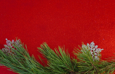 Red Christmas background with Christmas tree branch and Christmas balls and toys