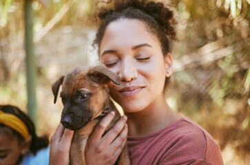 Love, dog and animal shelter with a black woman hugging a foster pet while at a shelter to adopt a...
